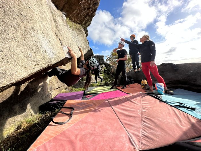 A boulder is climbing while Mammut athlete Anna Wild discusses beta with some of the squad kids.